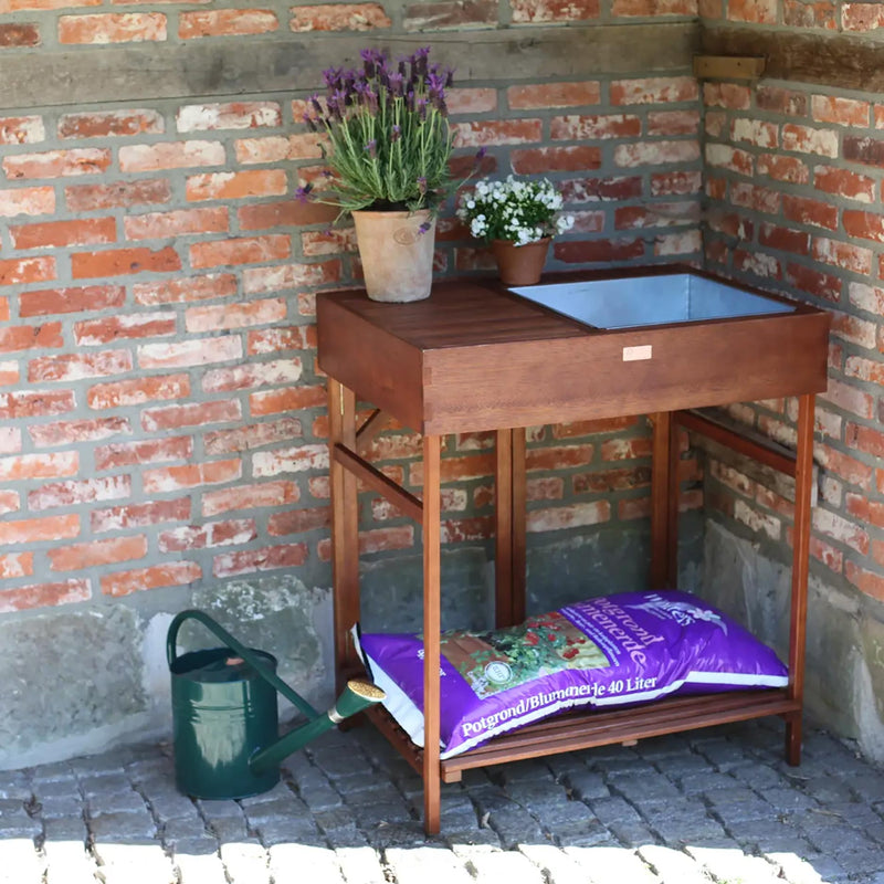 Houten oppotwerktafel met zaaibenodigdheden in de tuin